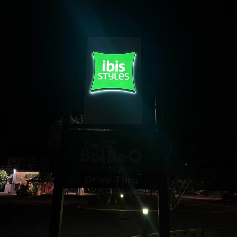 Illuminated Ibis Styles hotel signage displayed at night in Karratha WA