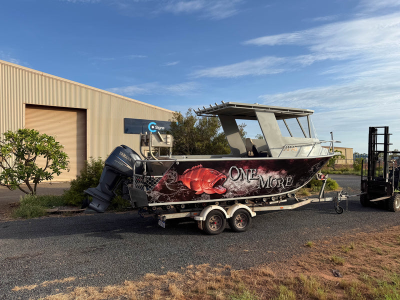 Dark fishing boat on a trailer with custom marine wrap, fish artwork and "one more" branding by C Signs in Karratha, Pilbara.