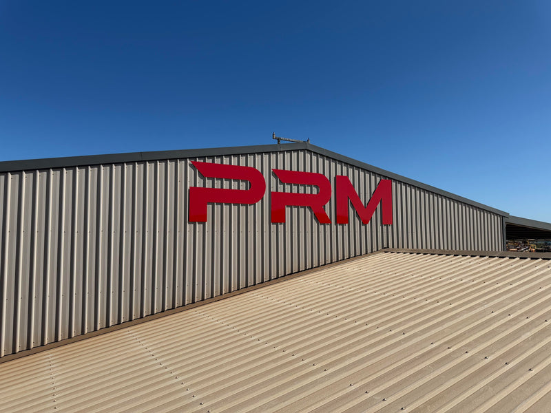 PRM building signage mounted on an industrial building exterior, installed in Karratha by C Signs Pilbara