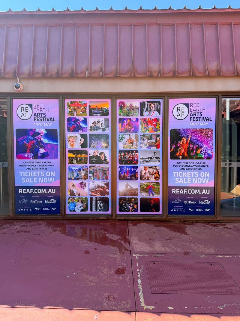 Red Earth Arts Festival event poster window graphics displayed across shopfront entrance, installed in Karratha by C Signs