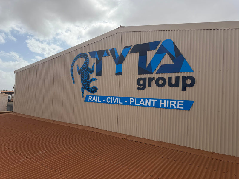 TYTA Group blue signage mounted on an industrial building exterior, installed in Karratha by C Signs 